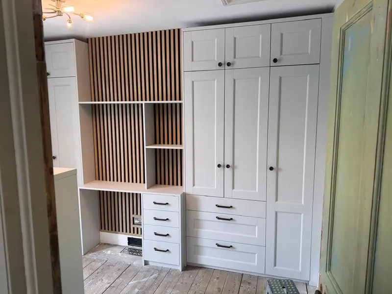 Bedroom with fitted wardrobes, drawers and slatted shelving