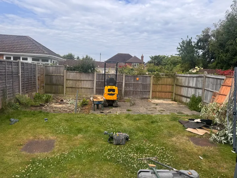Back garden cleared before landscaping, with a small digger