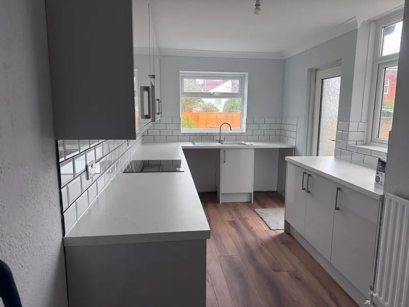 Grey gloss kitchen with white metro tiles and wood-effect floor