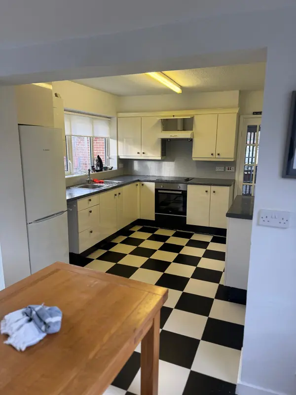 Old cream kitchen with a black and white floor before renovation