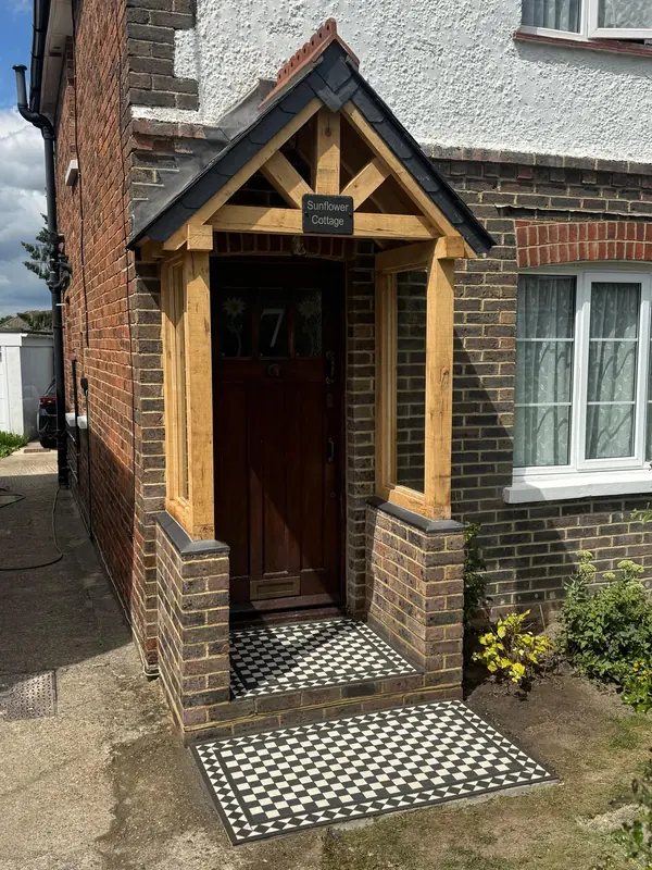 Oak-framed porch over a front door with a black and white tiled path
